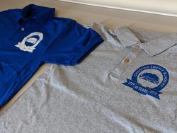 Two polo shirts with embroidered logos from "Christian Liberty Academy." One shirt is blue with a white logo, and the other is gray with a blue logo and text reading "1999-2019, 40 Years.